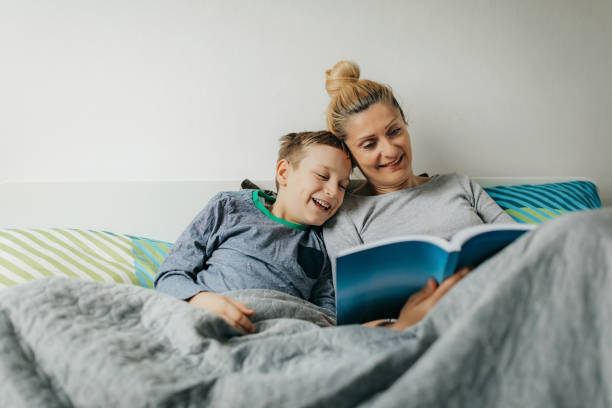 mãe e filho no quarto passam algum tempo de qualidade - women book mature adult reading - fotografias e filmes do acervo