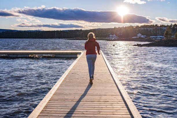 istock Sportswoman running on pier. 1225666159