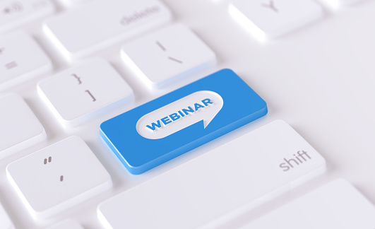 Webinar icon written on a blue button of a computer keyboard. Horizontal composition with selective focus and copy space. High angle view.  Webinar concept.