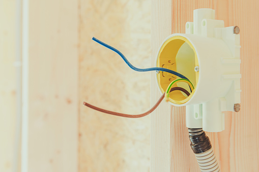 Close Up Of Wall Outlet Box With Set Of Wires Exposed In New Home Construction.