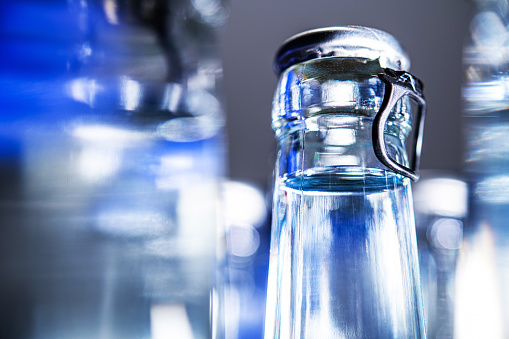 Close Up Of Clear Glass Mineral Water Bottles With Pop Up Tops.