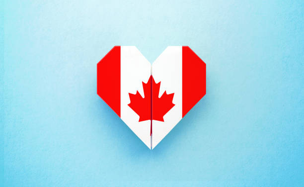Origami heart textured with  Canadian flag on turquoise background. Horizontal composition with copy space. Patriotism and Canada Day concept.