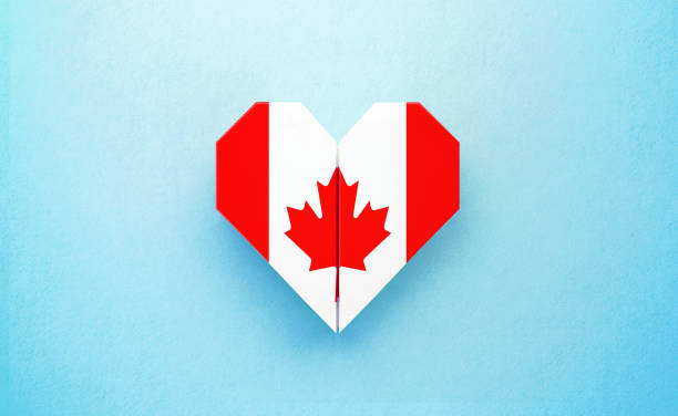 Origami heart textured with Canadian flag on turquoise background. Horizontal composition with copy space. Patriotism and Canada Day concept.
