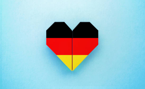istock Origami Heart Textured with German Flag on Turquoise Background 1225671627