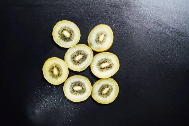 Photo of Juicy kiwi fruit on a black background.