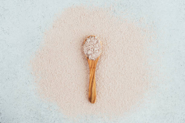 istock Pink clay in a wooden spoon on a pink, white background. 1225675170