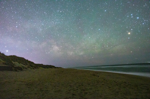 The stars in the night sky come out over the crashing waves of the beaches on Nantucket Island, Massachusetts