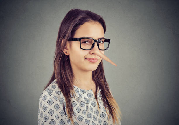 Sly tricky young woman liar Sly tricky young woman with long nose. Liar concept. falsehood stock pictures, royalty-free photos & images