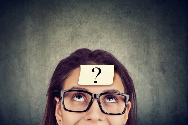 istock Woman wearing black glasses with question mark on forehead looking up. 1225681284