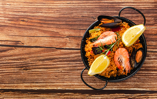 Vegetable paella with seafood, top view and copy space