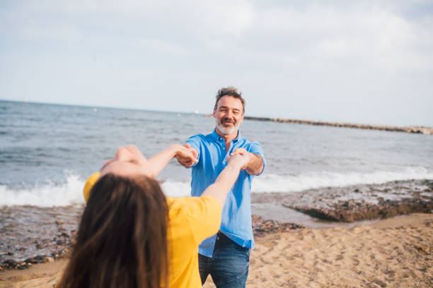 istock Woman and her husband having fun on the beach 1225684839