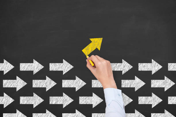 istock Going Your Own Way with Arrows Symbol on Blackboard Background 1225696354