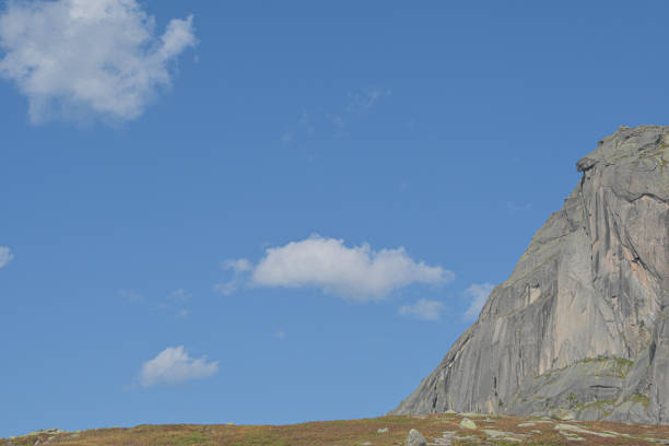 peak under blue sky with clouds, preparation for climbing rock ridge, journey in mountain valley
