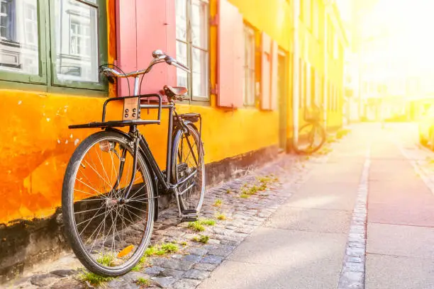 Photo of Old yellow house of Nyboder district with a bicycle. Old Medieval district in Copenhagen, Denmark