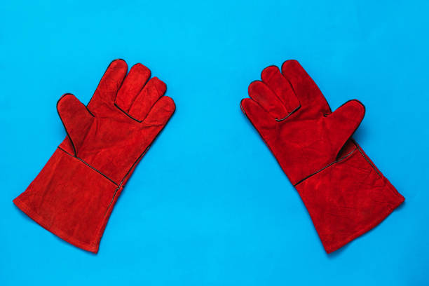 istock Bright red welding gloves on a blue background. 1225704599