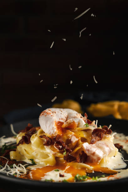 culinária italiana comida de fundo de massa carbonara fettucine com molho creme e cobertura de presunto com ovo cozido e bacon cozido e queijo parmesão, seletiva focada - sauces sweet sauce cooking traditional culture - fotografias e filmes do acervo