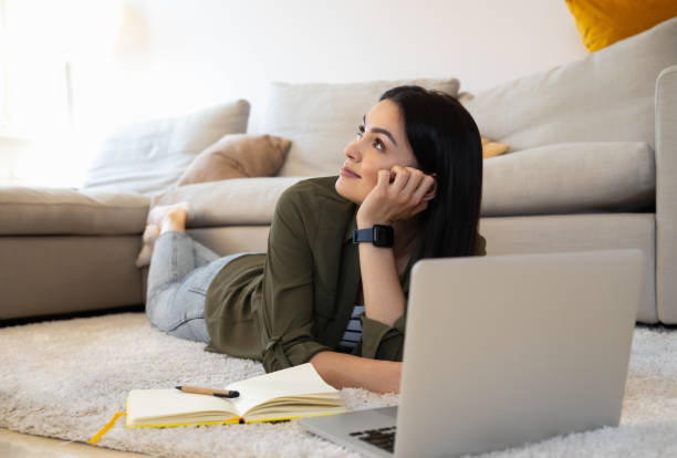 istock Dreamy lady at home with notes and modern gadget stock photo 1225706410