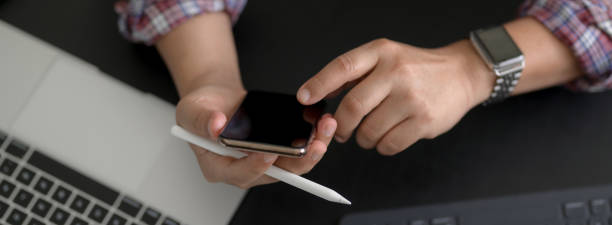 istock Overhead shot of businessman touching on smartphone while working with digital devices 1225716630