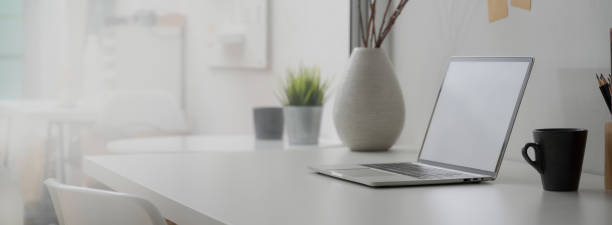 istock Side view of minimal home office desk with blank screen laptop, decorations and copy space 1225716655