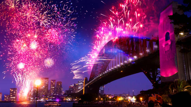 Sydney's Harbor Bridge at 2020's Annual New Year's Eve Fireworks Welcome Show Sydney, Australia - January 1, 2020: Sydney New Year's Eve Fireworks over Sydney Harbour with reflections on water and fireworks on bridge. firework explosive material photos stock pictures, royalty-free photos & images