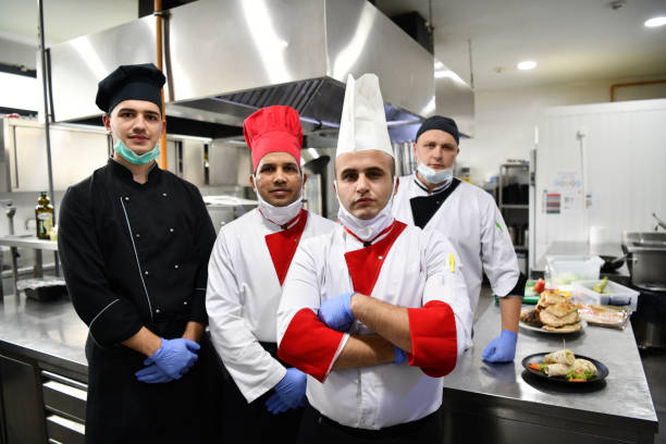 istock group chefs standing together in the kitchen at restaurant wearing protective medical mask and gloves in coronavirus new normal concept 1225719333