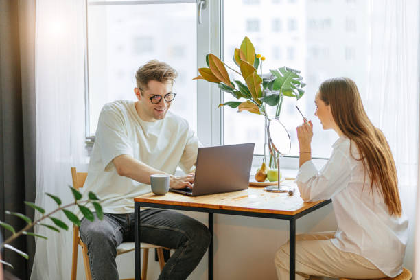 istock beautiful lady do make-up at morning while her husband work on laptop 1225721327