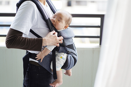 A mother and her five-month-old baby on a walk by baby carrier