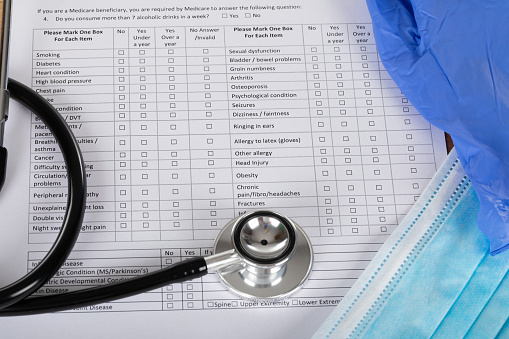 Medical record of sick patient and stethoscope on wooden table