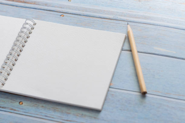 istock White binder blank notebook or diary or journal for writing text and message with pencil on blue pastel wood background with copy space. Still lifestyle photo concept. 1225728784