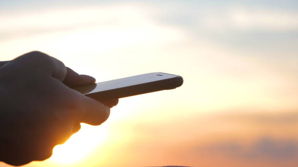 istock Woman using smartphone at sunset. Sunset light, golden hour 1225729243