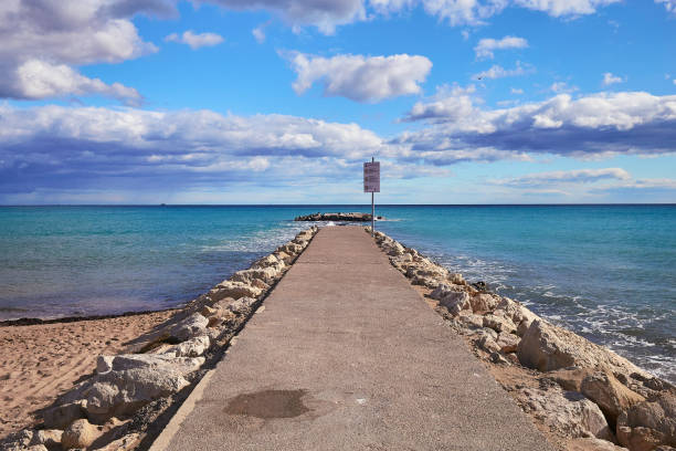 istock A pier of stones, a pier going into the sea. Dramatic sky with dark, heavy clouds. 1225732006
