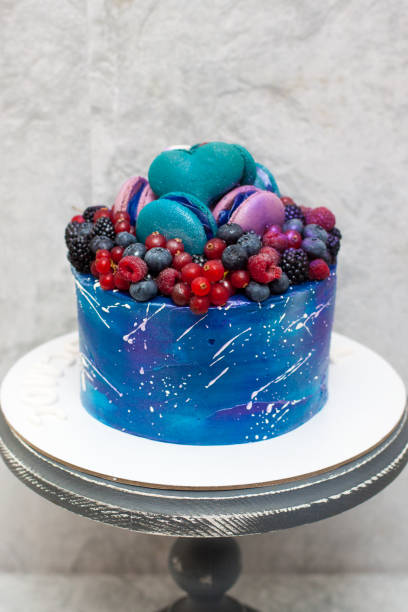 istock Space birthday cake decorated with fresh berries, macaroons and sprinkles. The concept of desserts for a birthday 1225733067