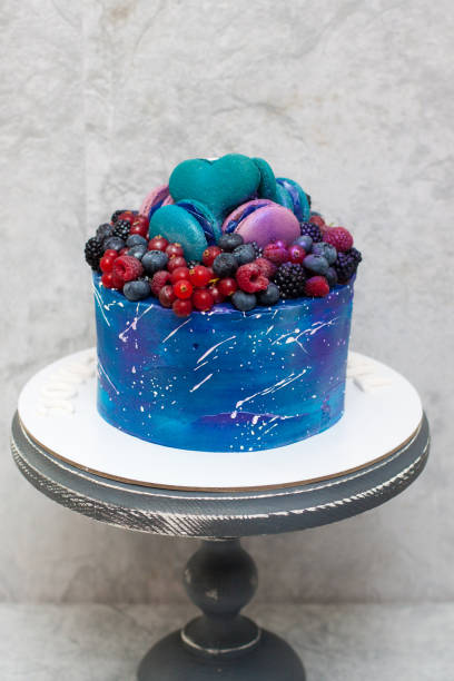 istock Space birthday cake decorated with fresh berries, macaroons and sprinkles. The concept of desserts for a birthday 1225733071