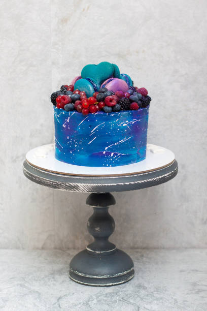 istock Space birthday cake decorated with fresh berries, macaroons and sprinkles. The concept of desserts for a birthday 1225733075