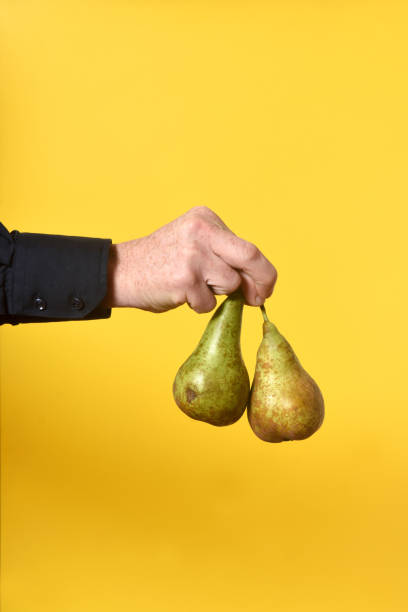 un homme retenant des choses et des objets sur le jaune - two pears photos et images de collection