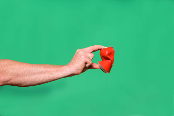 um homem segurando coisas e objetos em verde - crushed can soda drink can - fotografias e filmes do acervo