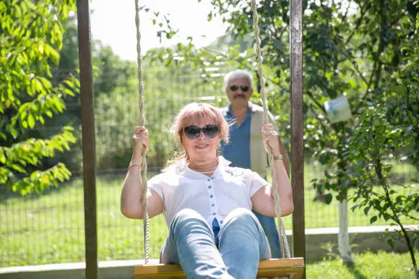 middle aged couple Senior couple on a swing.