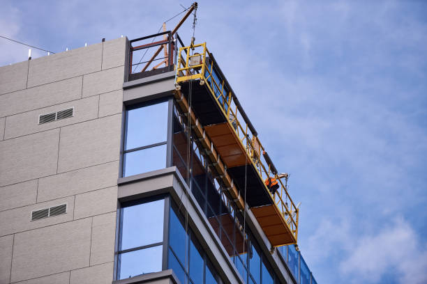 istock office building under construction. Facing and insulation of walls. Building elevator at the top of the building 1225734319