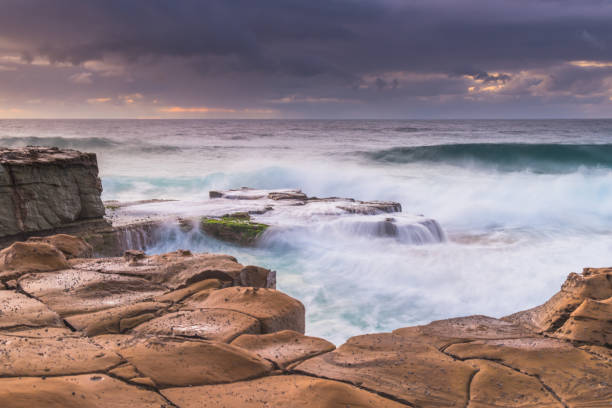 istock Rain Clouds and a Rocky Sunrise Seascape 1225737191