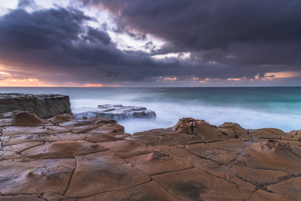 istock Rain Clouds and a Rocky Sunrise Seascape 1225737589