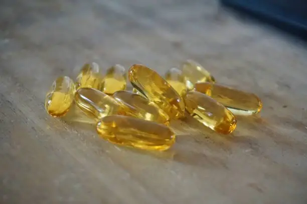 Omega 3 Capsules with wooden background