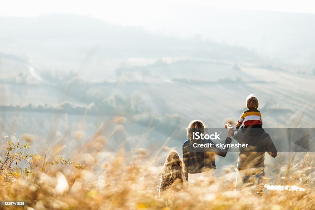 秋天那天,一個家庭站在山上的后視圖。 - 免版稅家庭圖庫照片