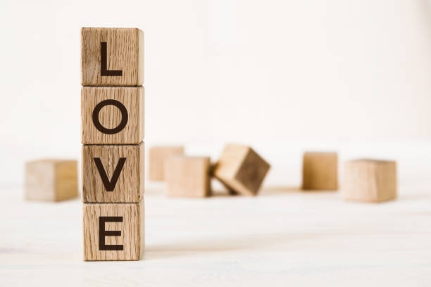 любовное послание, написанное деревянными блоками на светлом фоне - single word love wood typescript стоковые фото и изображения