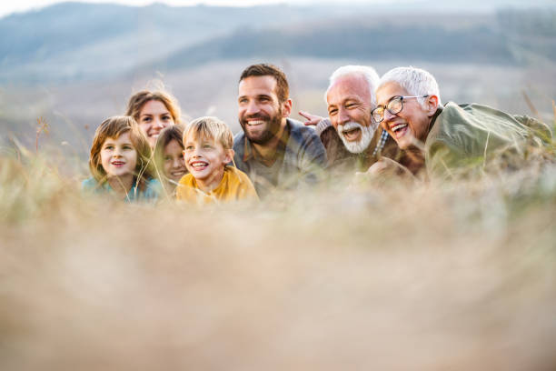 istock Happy extended family enjoying while relaxing in grass. 1225743419