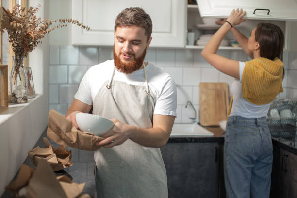 istock moving day, couple standing together in kitchen, unpacking carton package 1225744562