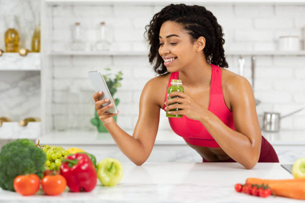 istock Afro Girl Drinking Smoothie And Checking Social Media 1225744696