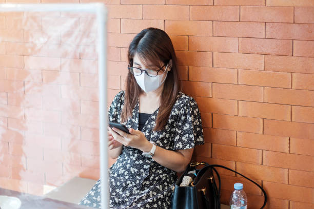 istock Asian woman using smartphone during dining time in restaurant with separated of shield plastic partition, protect coronavirus inflection. social distancing, new normal and life after covid-19 pandemic 1225745148