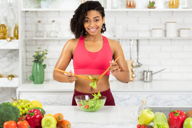 istock Beautiful young afro girl preparing vegetable salad 1225745658