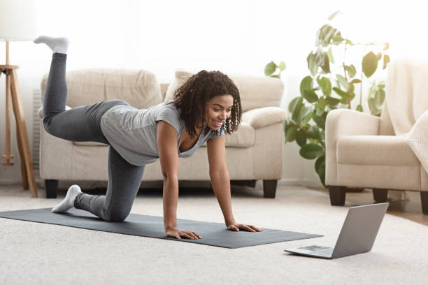 istock Fit Young Woman Excersising At Home, Watching Video Tutorial On Laptop 1225745823