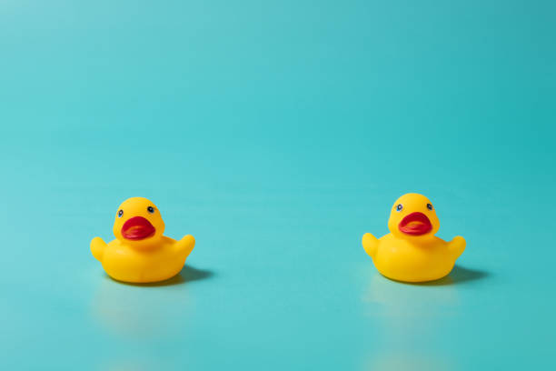 istock Yellow ducks far apart on blue background 1225746526